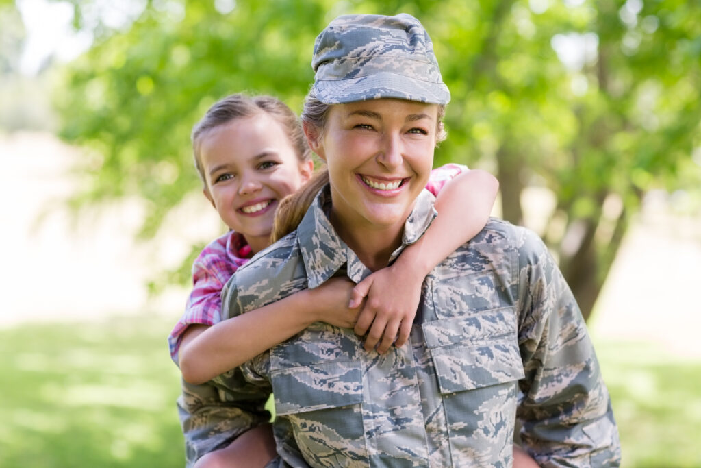 Woman soldier giving piggyback ride to daughter