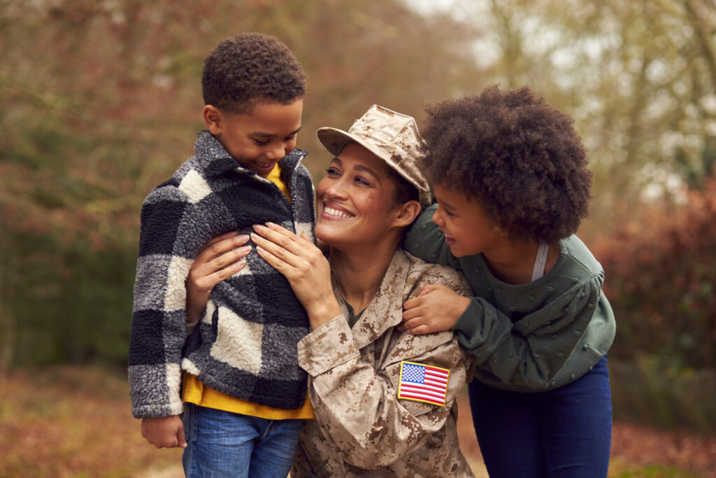 American Female Soldier In Uniform Greeted By Two Children