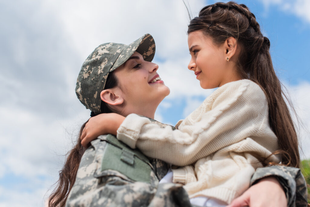 military woman embracing daughter