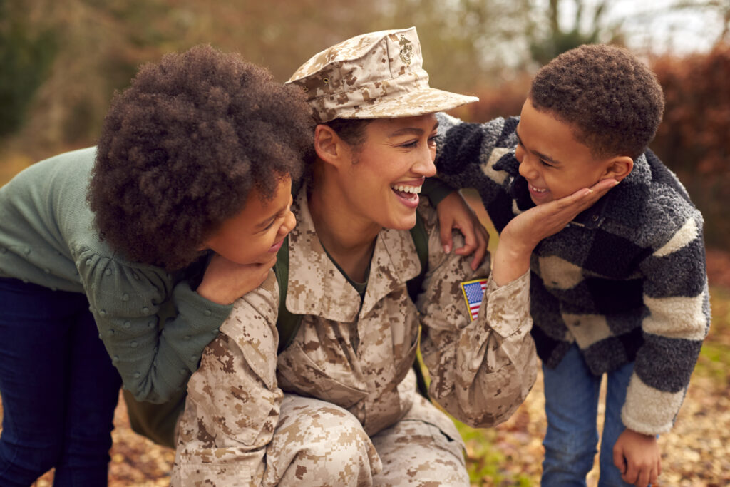 Woman Soldier In Uniform Returning Greeted By Two Children