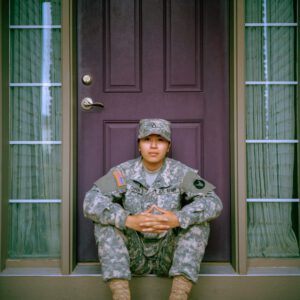 military woman sitting at door steps